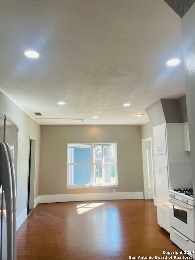 kitchen with hardwood / wood-style floors, white cabinets, and white gas range oven