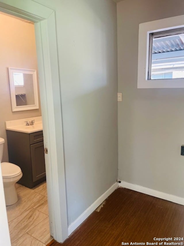 bathroom with toilet, hardwood / wood-style flooring, vanity, and plenty of natural light