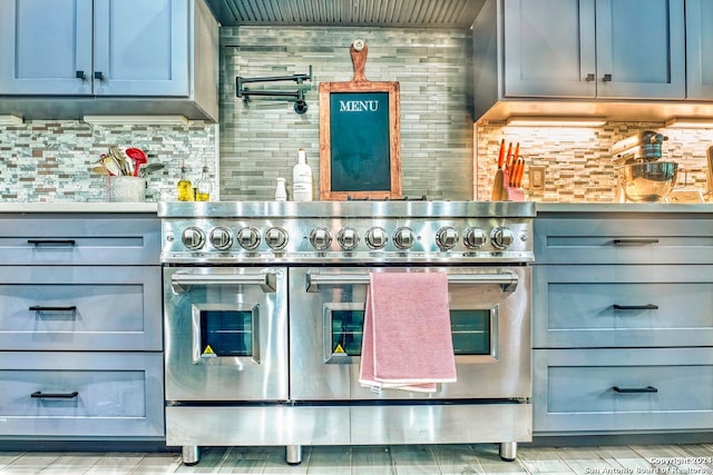 kitchen with range with two ovens and tasteful backsplash