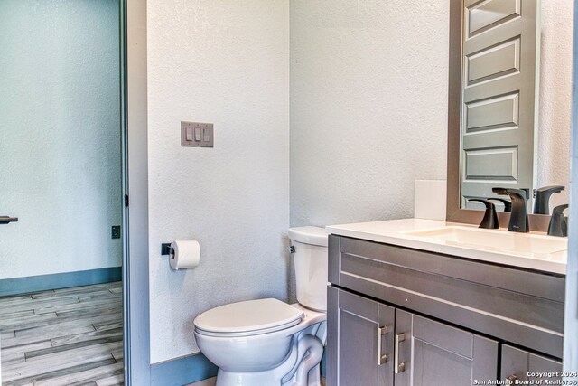 bathroom featuring hardwood / wood-style flooring, vanity, and toilet