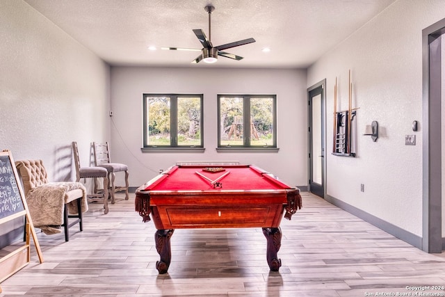 playroom featuring light hardwood / wood-style floors, pool table, ceiling fan, and a textured ceiling