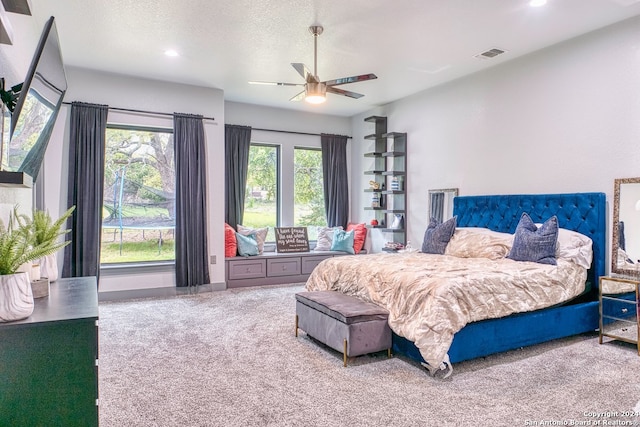 bedroom featuring multiple windows, carpet, ceiling fan, and a textured ceiling