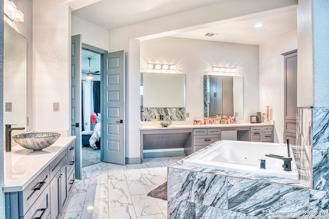 bathroom featuring tiled tub, ceiling fan, tile floors, and vanity