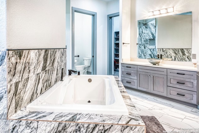 bathroom featuring vanity, tiled tub, toilet, and tile flooring