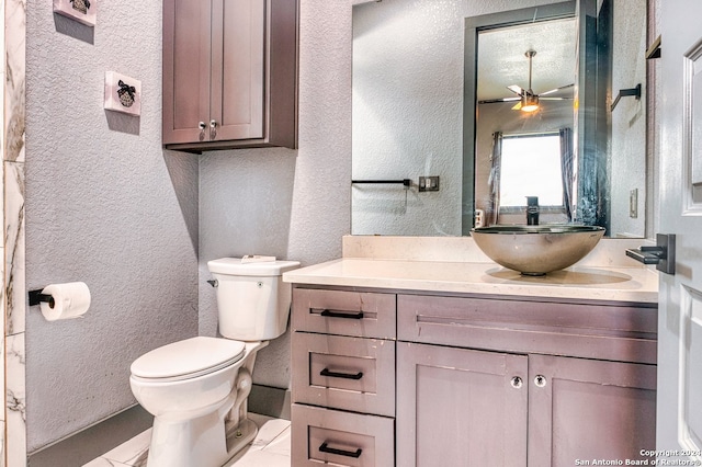 bathroom with toilet, oversized vanity, ceiling fan, and tile flooring