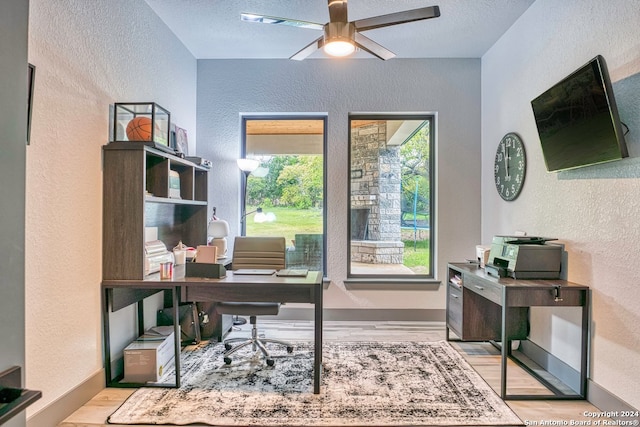 office with ceiling fan, a textured ceiling, and light wood-type flooring