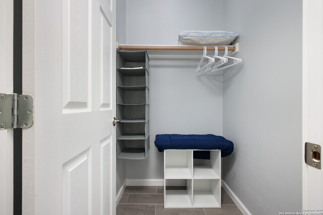 spacious closet with dark tile flooring