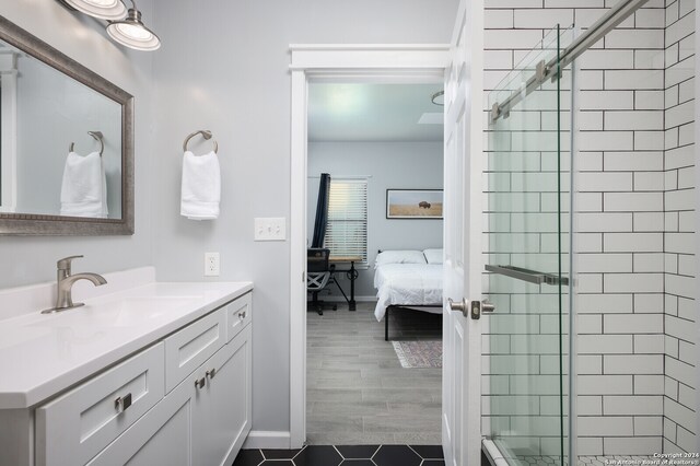 bathroom featuring tile flooring, vanity, and a shower with door