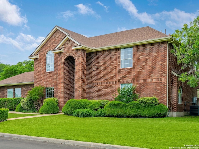 view of front facade featuring a front lawn and central AC unit