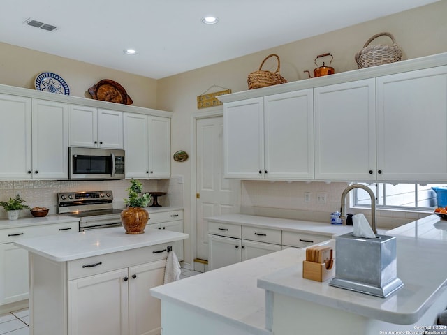 kitchen featuring white cabinets, tasteful backsplash, and stainless steel appliances