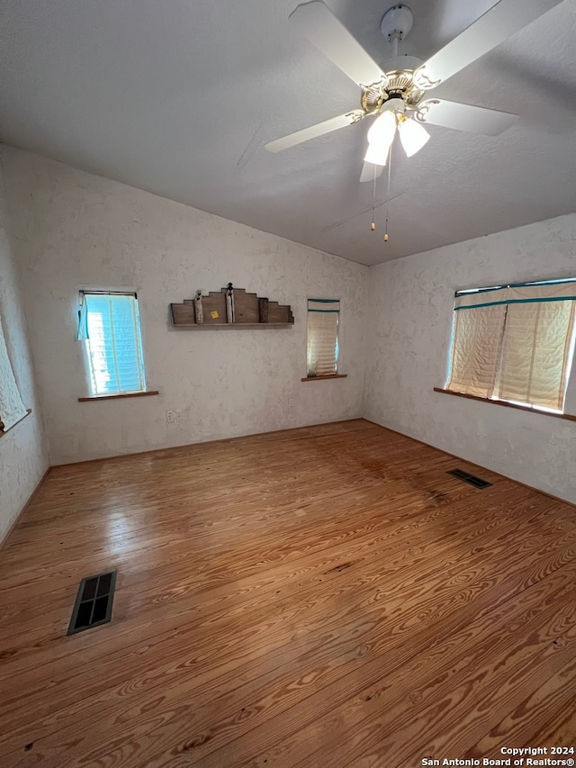 spare room with vaulted ceiling, ceiling fan, and hardwood / wood-style floors