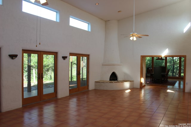 unfurnished living room featuring high vaulted ceiling, french doors, ceiling fan, and tile floors