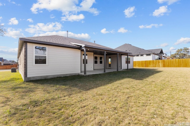 back of house with a yard and a patio