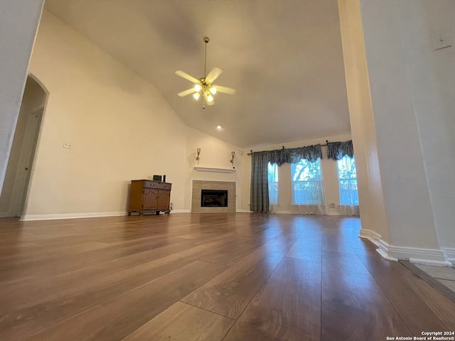 unfurnished living room with wood-type flooring, ceiling fan, high vaulted ceiling, and a fireplace