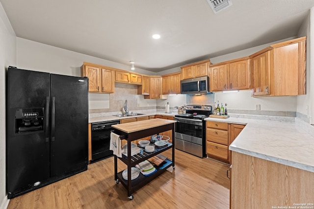 kitchen featuring sink, light wood-type flooring, and black appliances