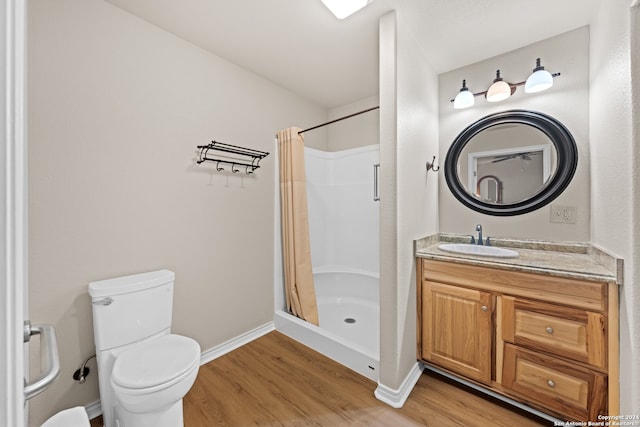 bathroom featuring walk in shower, vanity, hardwood / wood-style flooring, and toilet