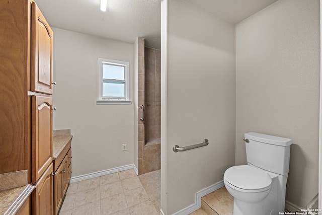 bathroom with toilet, tile floors, and vanity