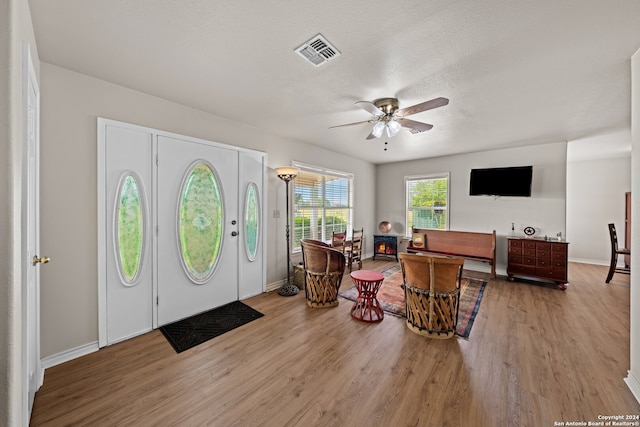 foyer entrance featuring wood-type flooring, a textured ceiling, and ceiling fan