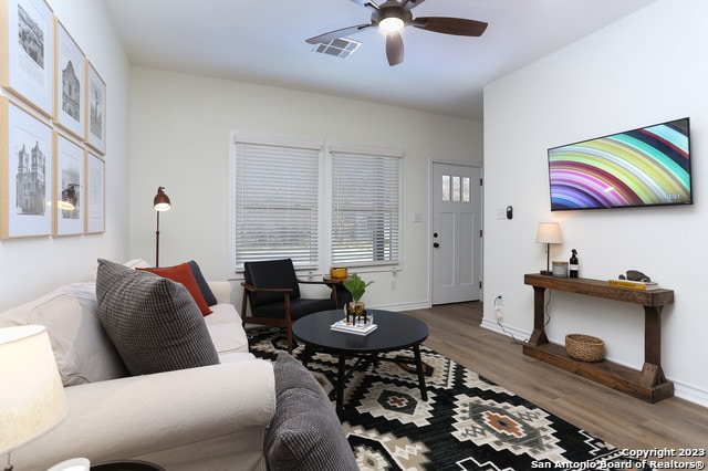 living room with ceiling fan and dark hardwood / wood-style flooring