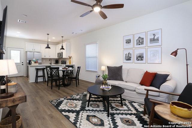 living room featuring hardwood / wood-style flooring and ceiling fan