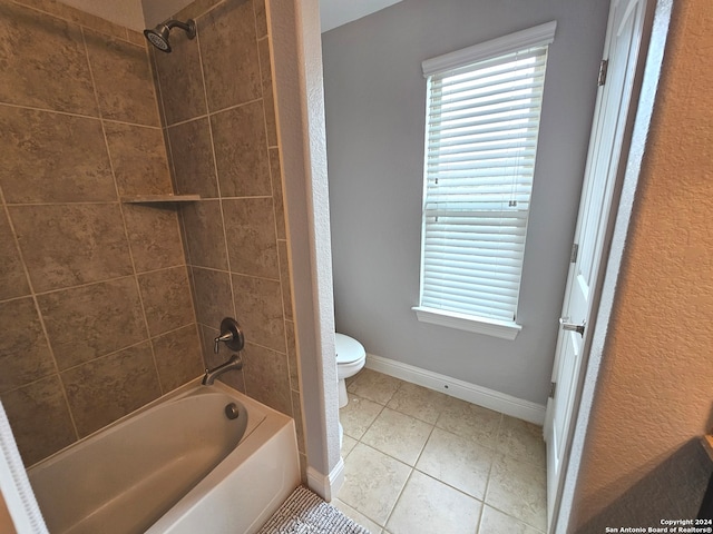 bathroom with tile floors, toilet, and tiled shower / bath