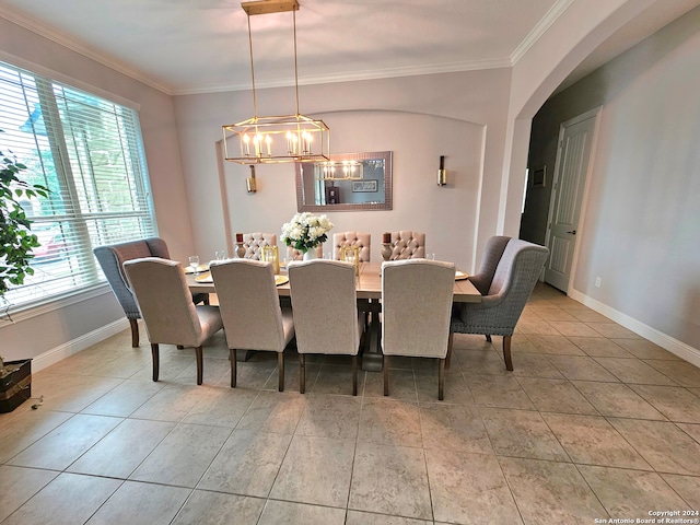 dining area featuring crown molding, an inviting chandelier, and tile floors