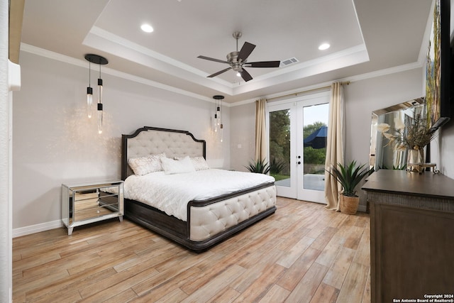 bedroom featuring hardwood / wood-style flooring, crown molding, french doors, and a tray ceiling