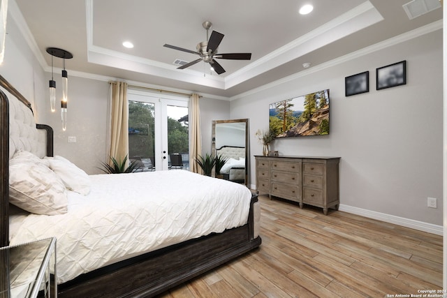 bedroom with light hardwood / wood-style flooring, a raised ceiling, crown molding, and access to exterior