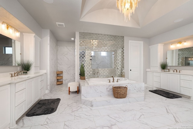 bathroom featuring a tray ceiling, vanity, tile floors, and tiled bath