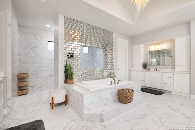 bathroom featuring a relaxing tiled bath, plenty of natural light, tile floors, and vanity