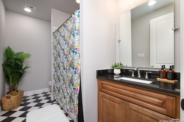 bathroom with toilet, tile floors, and vanity