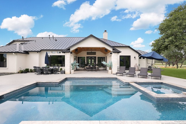 exterior space with a swimming pool with hot tub, a patio area, and outdoor lounge area