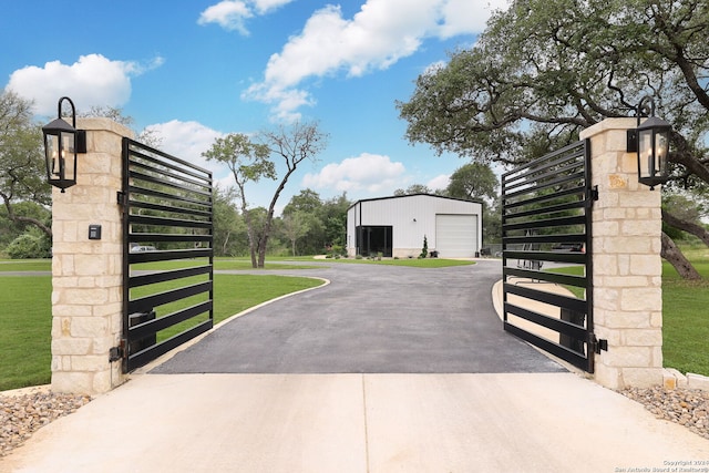 view of gate featuring a lawn and an outdoor structure