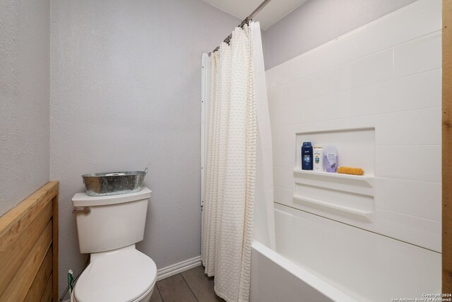 bathroom featuring shower / tub combo, toilet, and wood-type flooring