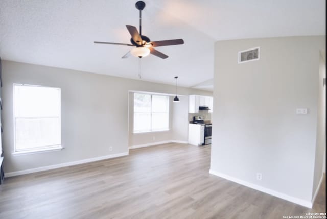 empty room with ceiling fan, hardwood / wood-style floors, and lofted ceiling