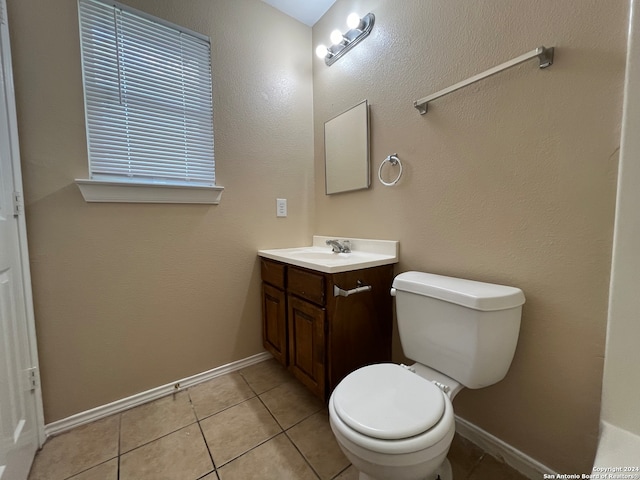 bathroom with tile flooring, vanity, and toilet