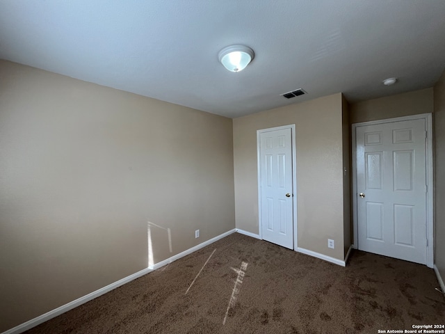 unfurnished bedroom with dark carpet