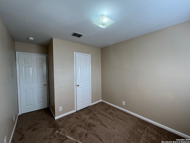 unfurnished bedroom with dark colored carpet