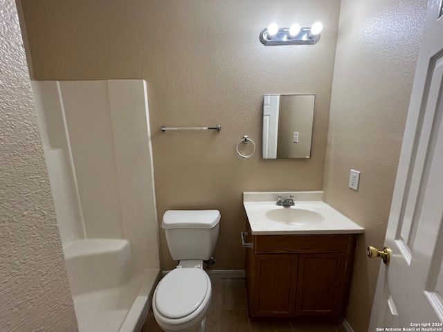 bathroom with toilet, tile flooring, and vanity