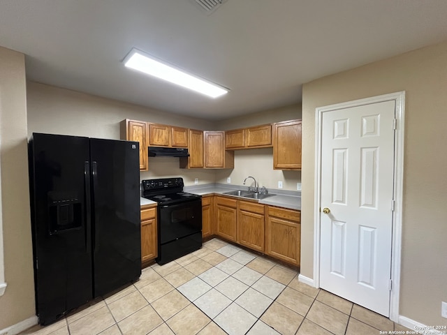 kitchen with sink, light tile flooring, and black appliances