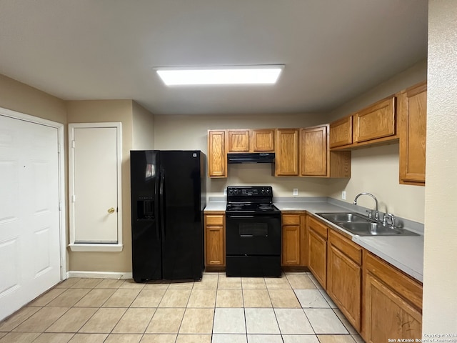 kitchen with sink, light tile floors, and black appliances