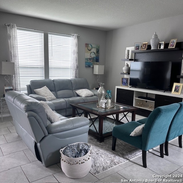 living room with light tile floors and a textured ceiling