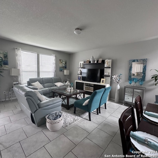 tiled living room featuring a textured ceiling