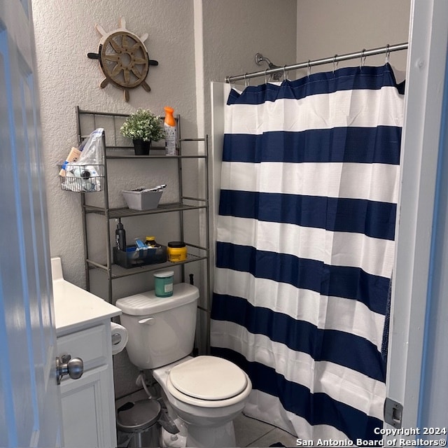 bathroom featuring vanity, toilet, and tile flooring