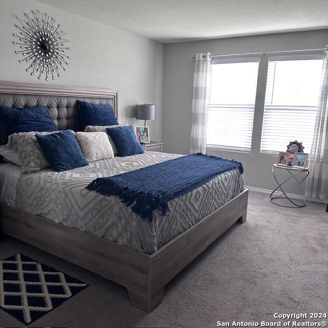 bedroom with a textured ceiling and carpet flooring