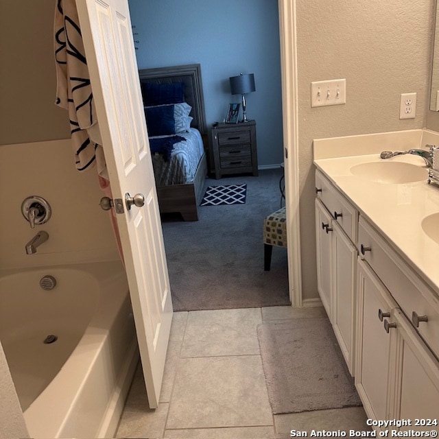 bathroom featuring a bathing tub, tile flooring, and vanity