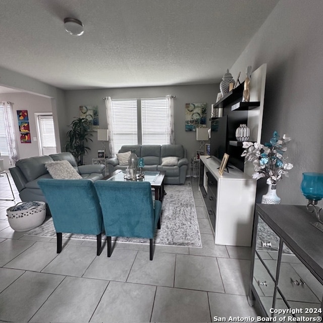 living room featuring light tile floors and a textured ceiling