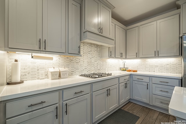 kitchen featuring dark hardwood / wood-style floors, tasteful backsplash, gray cabinets, and stainless steel gas stovetop