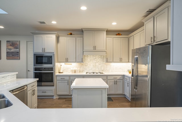 kitchen featuring a center island, premium range hood, dark wood-type flooring, backsplash, and stainless steel appliances