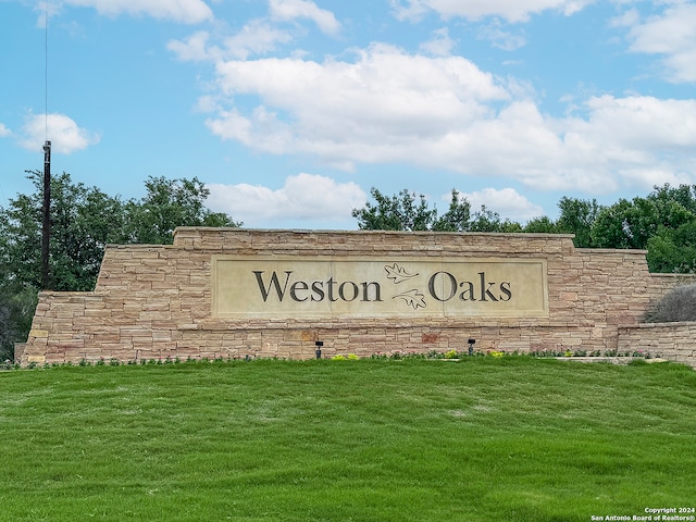 community / neighborhood sign featuring a yard